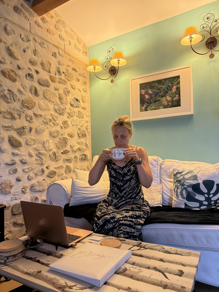 Sandrine dégustant un thé dans le salon cosy d'une maison d'hôtes en pierre