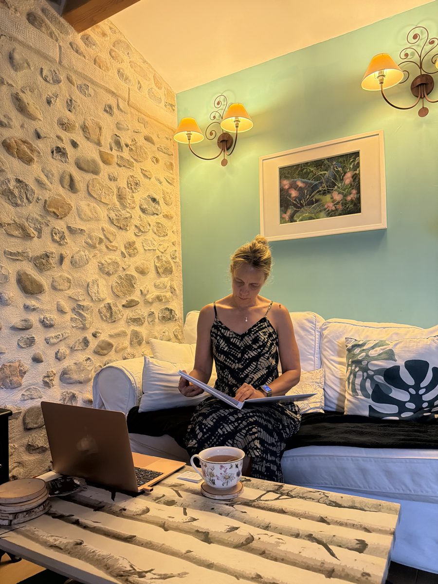 Sandrine en pleine lecture dans le salon cosy d'une maison d'hôtes en pierre
